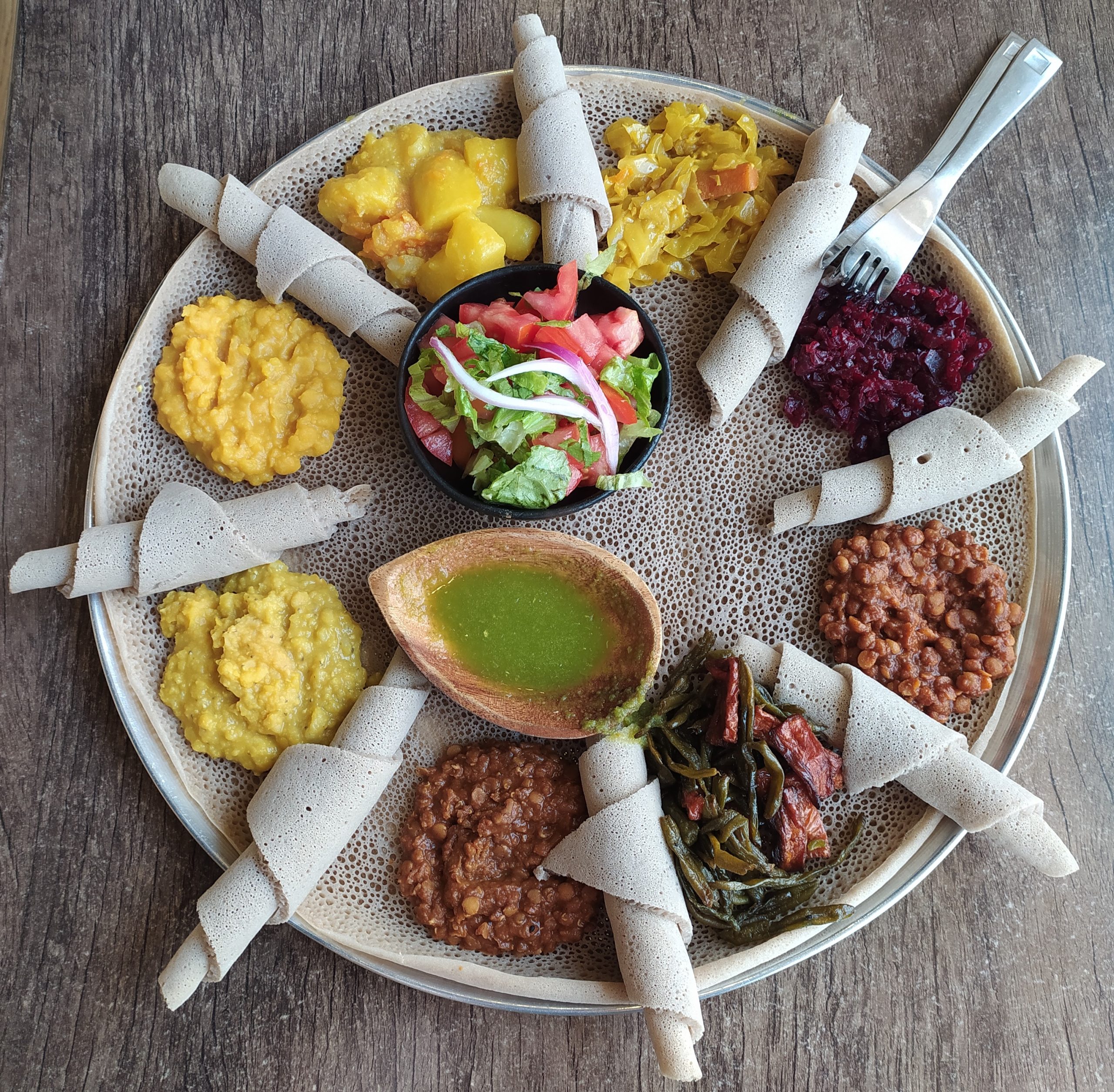 Beyaynetu-style injera topped with eight different Ethiopian stews