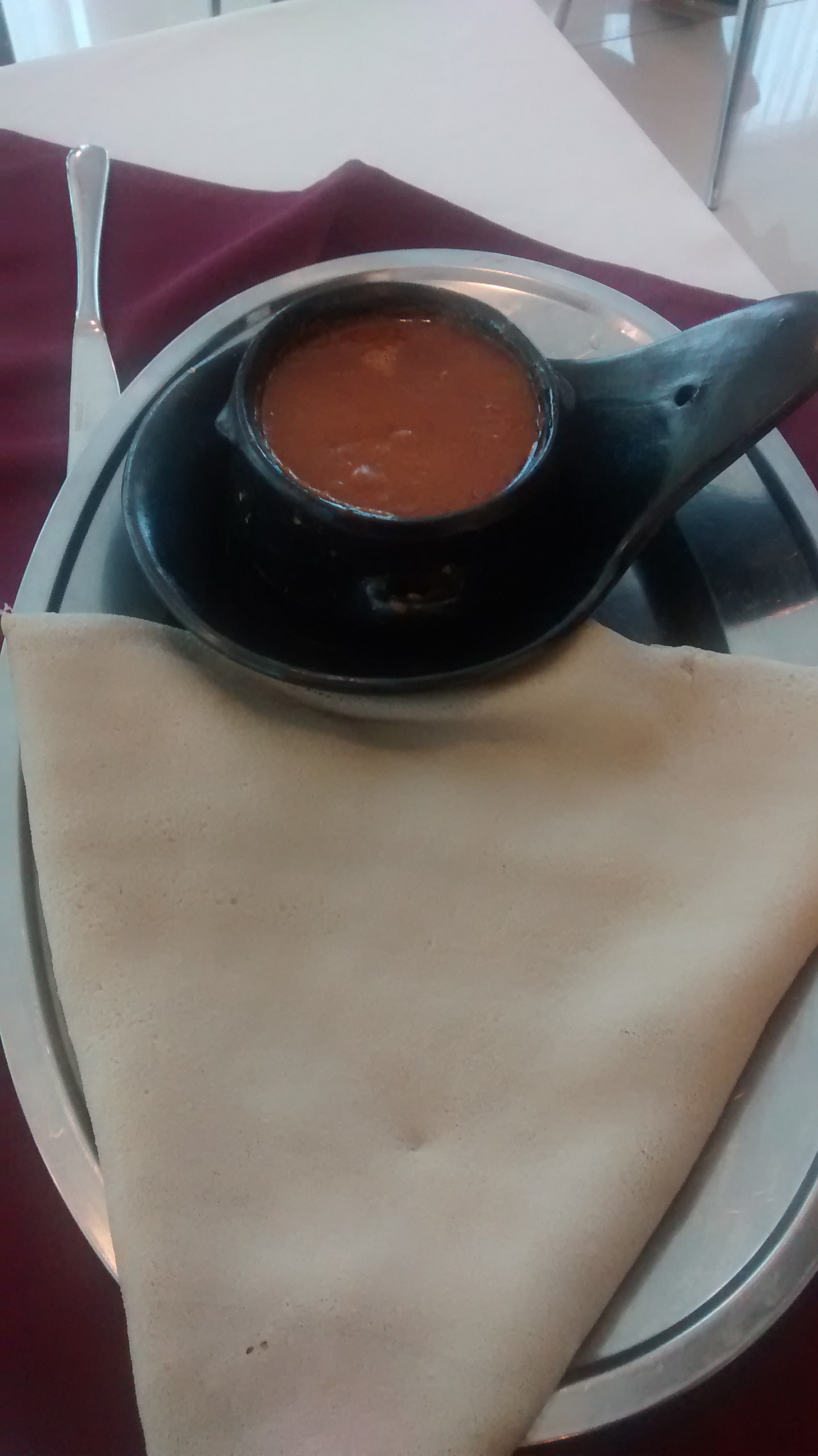 Shiro wet, Ethiopian chickpea stew, served bubbling in a clay dish with injera